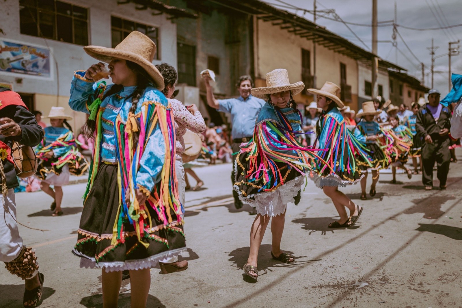 Costumed dancers filling a Cajamarca street during Carnival