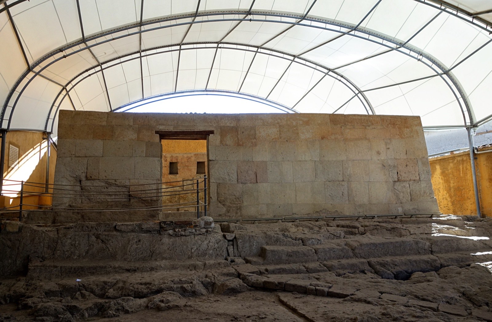 The Ransom Room under its protective roof, a single stone chamber with a doorway at the top of worn steps